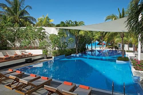 - une piscine avec des chaises longues et un complexe dans l'établissement Dreams Sands Cancun Resort & Spa, à Cancún