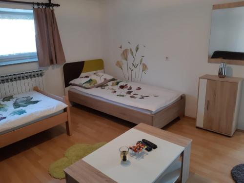 a small room with two beds and a table at Apartment Upper Town in Gospić