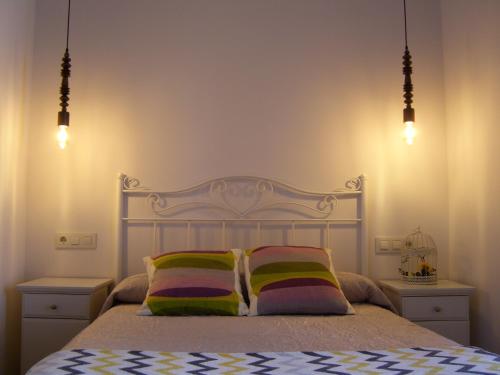 1 dormitorio con 1 cama blanca y 2 almohadas coloridas en PR Tambre, en Santiago de Compostela