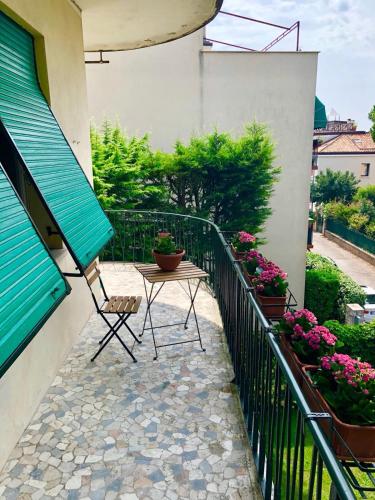 a table and chair on a balcony with flowers at Ca Nart in Venice-Lido