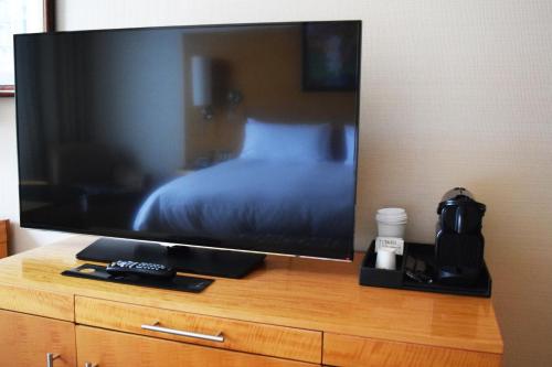 a flat screen tv sitting on top of a wooden desk at Sofitel Montreal Golden Mile in Montreal