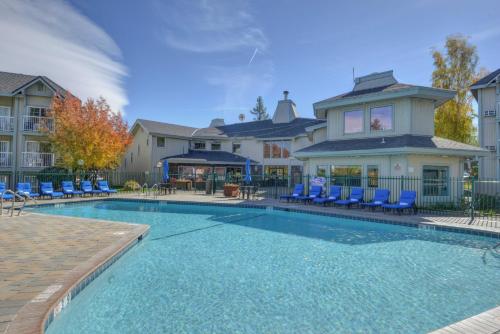 ein Pool mit blauen Stühlen und ein Haus in der Unterkunft Beach Retreat & Lodge at Tahoe in South Lake Tahoe