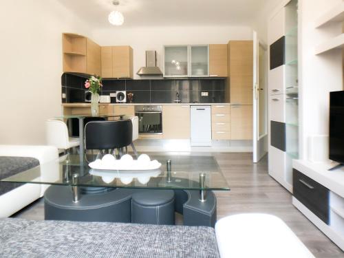 - une cuisine avec une table en verre et des chaises dans la chambre dans l'établissement Apartment Lara, à Vienne