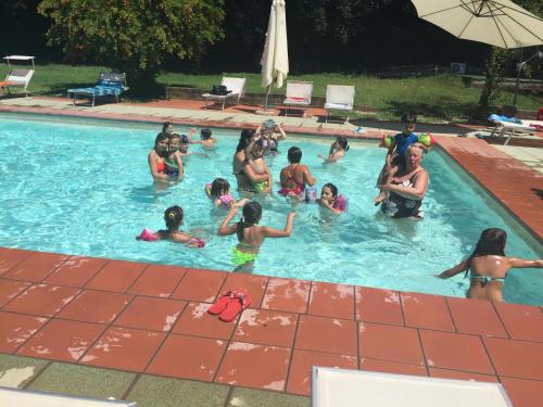 um grupo de pessoas numa piscina em Agriturismo Casale Loreto em Corchiano
