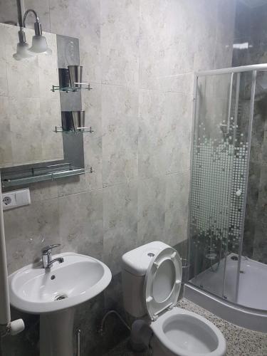 a bathroom with a toilet and a sink and a shower at SResidence in Tbilisi City