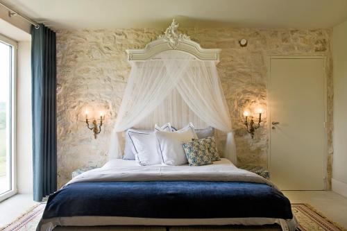 a bedroom with a large bed with a white canopy at Domaine de L'Isle Basse in Fontanes
