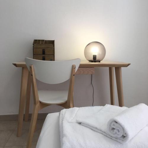 a desk with a chair and a table with a lamp at Case sul mare in Palau
