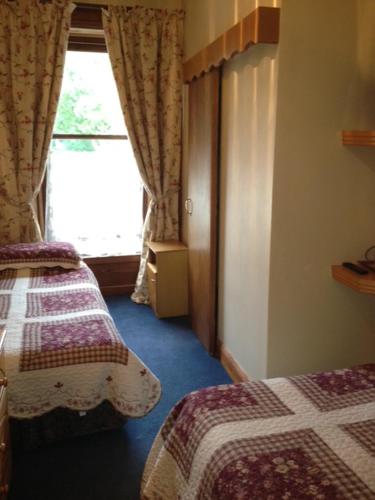 a hotel room with two beds and a window at Ballyglass Country House in Tipperary