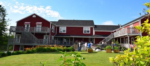 a large red house with people standing outside of it at Auberge Wild Rose Inn in Moncton