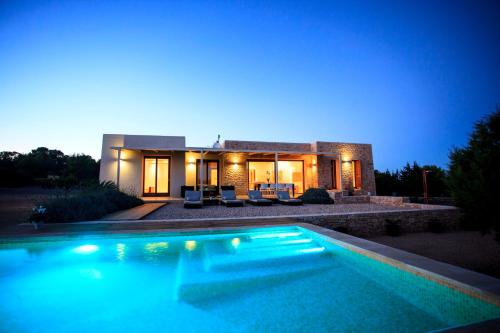 una casa con piscina frente a ella en Can Corda Formentera en Cala Saona