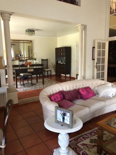 ein Wohnzimmer mit einem weißen Sofa und einem Tisch in der Unterkunft Quinta Nova do Almeida in Alcobaça