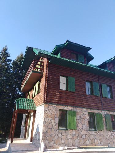 a large brick building with a green roof at Apartments Durmitor in Žabljak