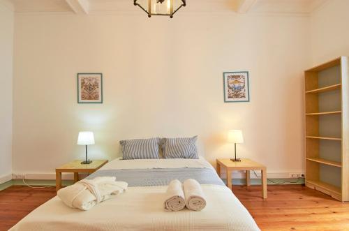 1 dormitorio con 1 cama con toallas en Palácio SantAnna, en Lisboa