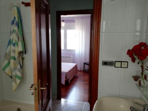 a bathroom with a tub and a bedroom with a bed at Apartamento Santa Marta in Santiago de Compostela