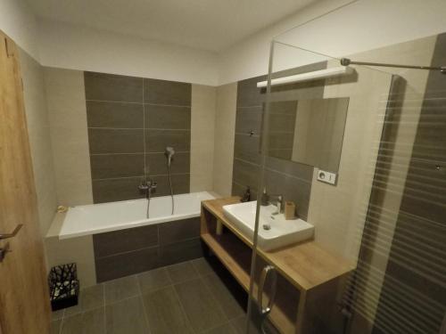 W łazience znajduje się wanna, umywalka i prysznic. w obiekcie Lipno Vision Apartments w mieście Lipno nad Vltavou