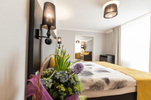 クリニツァ・ズドルイにあるApartamenty w Williのベッドルーム1室(椅子に花を飾ったベッド1台付)