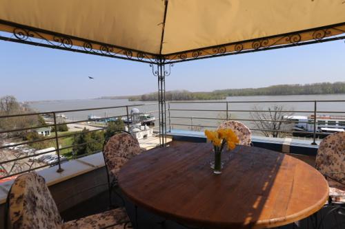 a table with chairs and a vase of flowers on a balcony at Hotel Neptun in Vidin