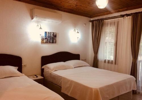 1 dormitorio con 2 camas y ventana en Aydeniz Otel, en Mesudiye