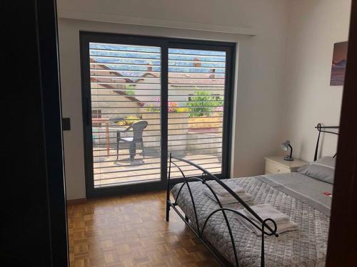 a bedroom with a bed and a door to a balcony at Casa Ines in Bellinzona