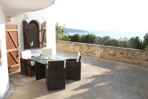 a patio with a table and chairs and the ocean at Charly Point Villa in Methoni