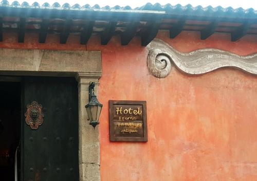 a sign on the side of a building with a door at Hotel Eterna Primavera Antigua in Antigua Guatemala
