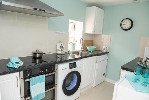 a kitchen with a washing machine and a sink at Pinehill Rooms in Reading