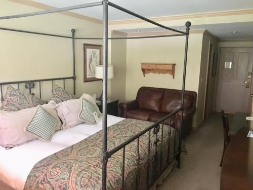 a bedroom with a four poster bed and a chair at Lodge Tower in Vail