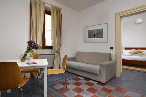 a living room with a couch and a table and a bed at Roma Resort Termini in Rome