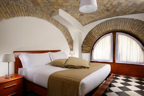 una camera con un grande letto con un muro di mattoni di Roma Resort Termini a Roma