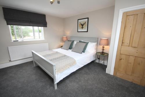 a bedroom with a white bed and a window at Malvern House in Banbury