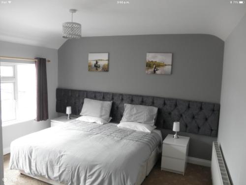 a bedroom with a large bed with white sheets and pillows at Fitzpatrick's Tavern and Hotel in Cavan