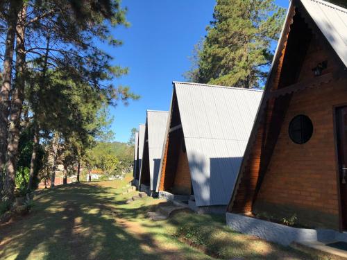 una fila de cabañas en un parque con árboles en Chalés Verde Vida, en Conservatória