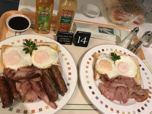 two plates of food on a table with eggs and meat at Cudgegong Valley Motel in Mudgee