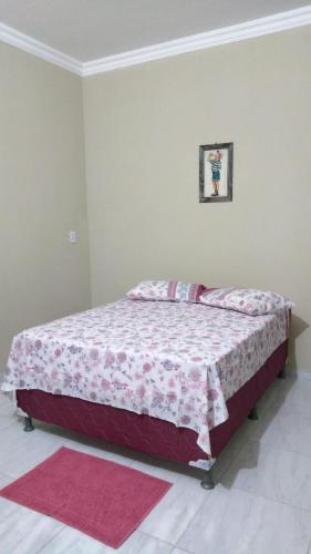 a bedroom with a bed with a pink blanket at Chalés Porto do Céu in Aracati
