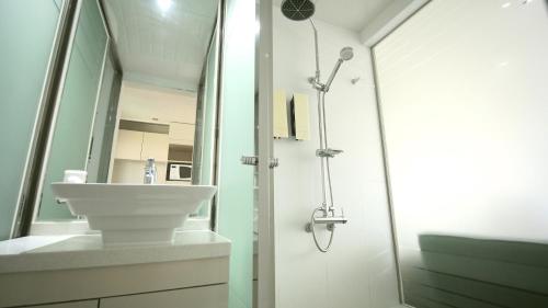 a bathroom with a sink and a shower at Residence Mumum Hotel in Busan
