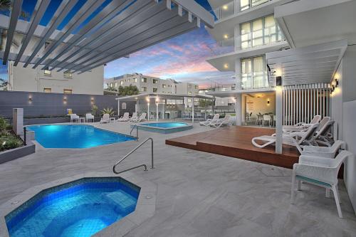 a house with a swimming pool and a patio at Catalina Resort in Maroochydore