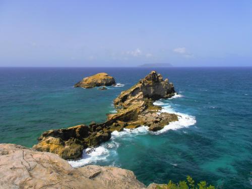 an aerial view of a rocky island in the ocean at Les Manguiers in Deshaies