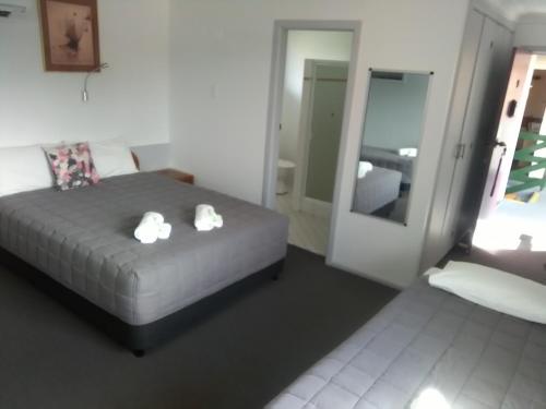 a bedroom with a bed with two white towels on it at Civic Motel Grafton in Grafton