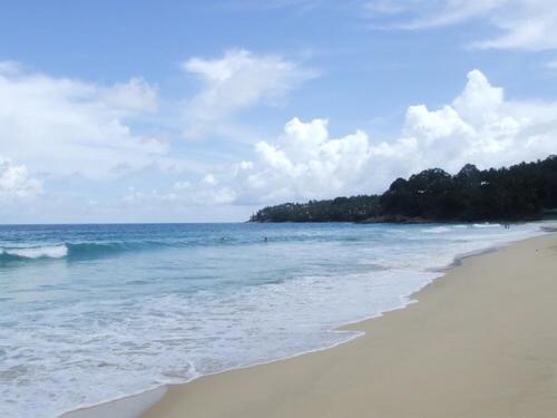a beach with the ocean and trees in the background at Chill land house in Bang Tao Beach