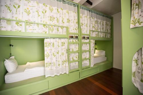 a room with two bunk beds with curtains at Memmoth Hostel In Lampang in Lampang