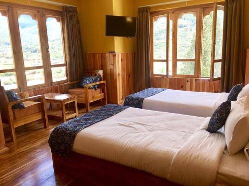 um quarto de hotel com duas camas e duas janelas em Hotel Khamsum em Paro