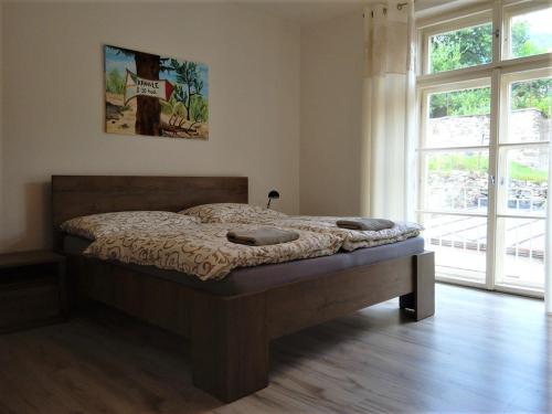 a bedroom with a bed in a room with windows at Apartmán s výhľadom in Kremnica