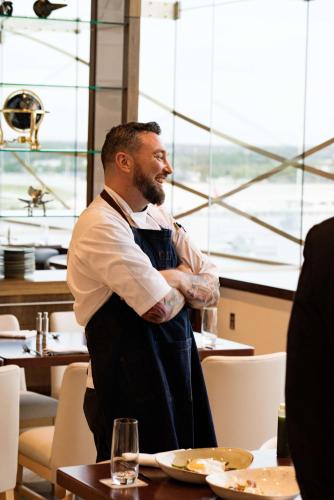 a man standing in a restaurant with his arms crossed at Hyatt Regency Orlando International Airport Hotel in Orlando
