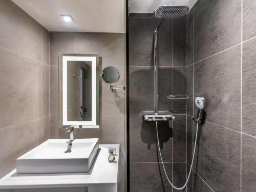 een badkamer met een wastafel en een douche bij Novotel Mexico City Santa Fe in Mexico-Stad