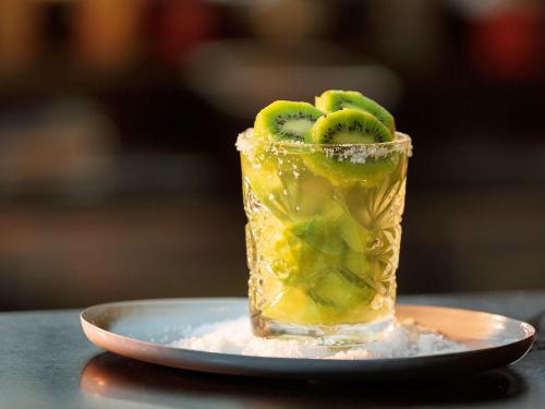 a drink with kiwi and kiwis on a plate at ibis Sydney Olympic Park in Sydney