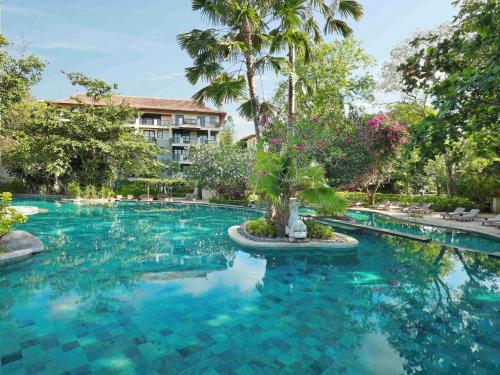 a swimming pool in front of a resort at Novotel Bali Nusa Dua in Nusa Dua