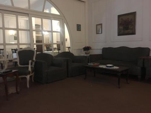 a living room with couches and a table and a window at Pension Roma in Cairo