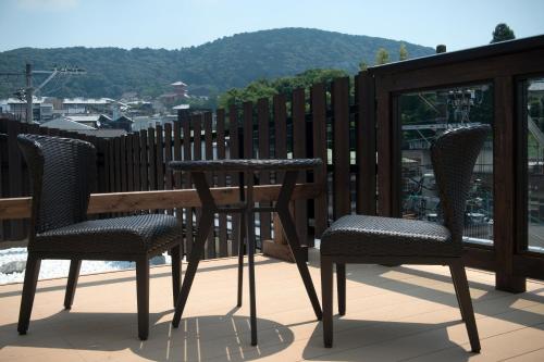 a table and chairs on a balcony with a view at Terrace Kiyomizu Kyoto in Kyoto