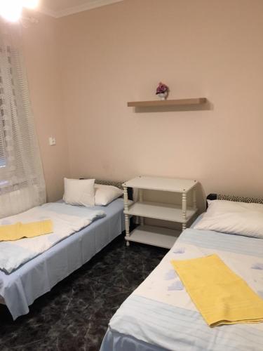 a room with two beds and a shelf on the wall at Csini Panzió Drinkbár in Gyál