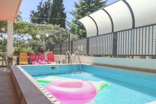 a swimming pool with a pink bath tub in it at Apartment Marjan Park in Split